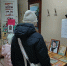 Интерьер библиотеки: на столе выставлены резные деревянные панно; посетители стоят спиной, вид со входа в читальный зал. - 168.Ru