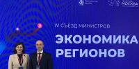 На изображении двое людей стоят на фоне синего баннера с текстом. Текст сообщает о съезде министров экономики регионов в Москве., Изображение. - Минэкономразвития