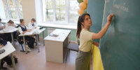 Учительница у школьной доски, ученики за партами в классе. - 168.Ru