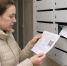 женщина у почтовых ящиков держит платёжную квитанцию с крупным QR‑кодом - 168.Ru