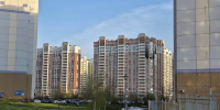Двор новых жилых высоток: газон, дорожка, молодые деревья и парковка вдоль домов - Newsroom24.Ru